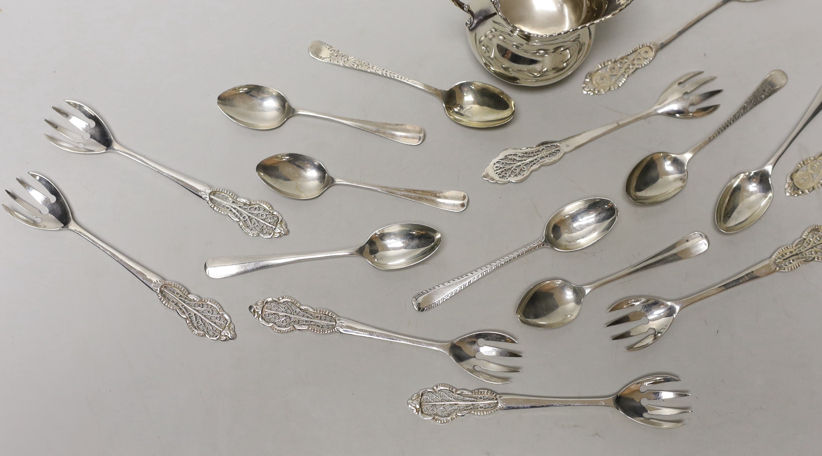 A silver cream jug and sundry minor spoons and forks.